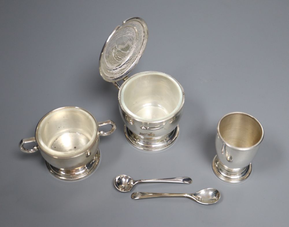 A modern cased silver three piece condiment set, with two later spoons, Wakely & Wheeler, London, 1957, 5oz.